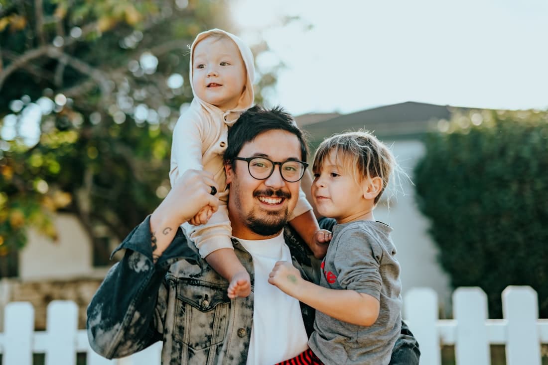 A father carrying his two young children